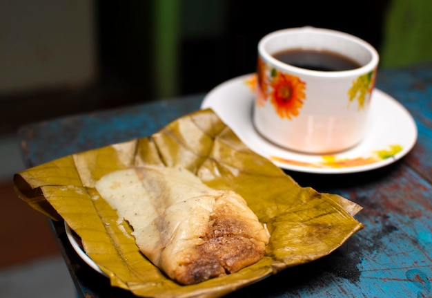 Gefüllte Tamale serviert auf Holztisch Gefüllte Tamale auf Bananenblatt serviert auf Holztisch