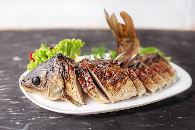 Gefüllter Fisch mit Salat, Pfeffer und Zitrone. Das Konzept des Essens