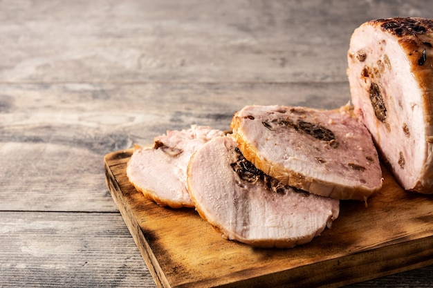 Gefülltes Huhn mit Nüssen auf rustikalem Holztisch