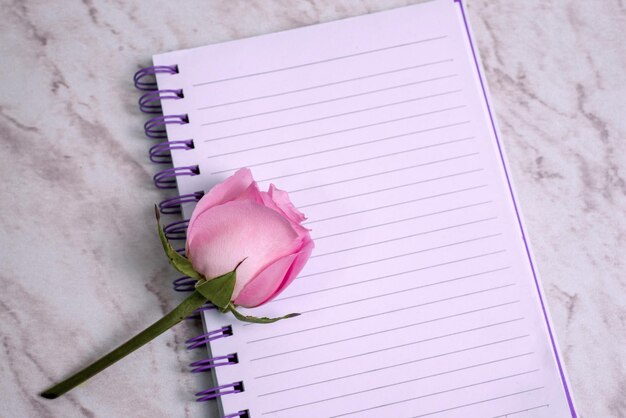 Gefüttertes Notizbuch mit Blumen auf Marmortisch