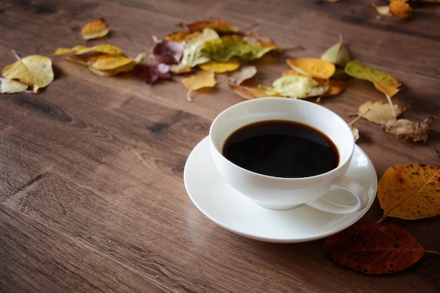 Gegenstände auf einem Holztisch eine Tasse Kaffee und ein Buch