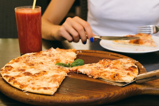 Gegessene Pizza und Glas Tomatensaft auf dem Tisch in der Pizzeria