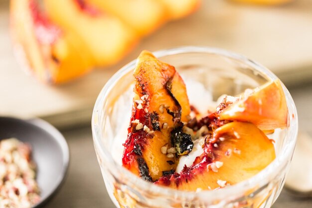 Gegrillte Bio-Pfirsiche und Pekannüsse auf Vanilleeis.