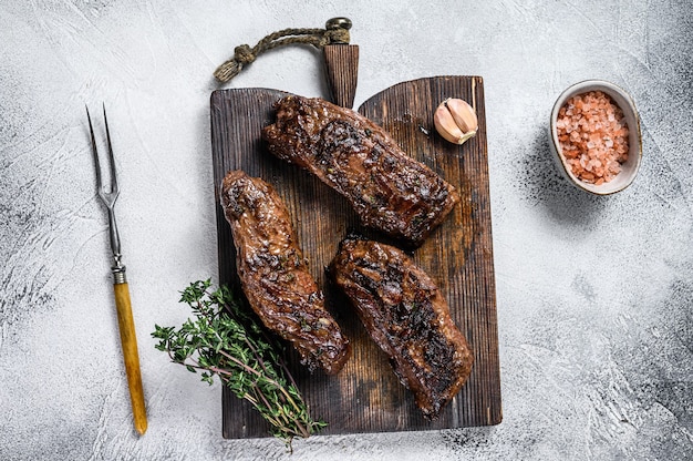 Gegrillte Brisketsteaks in Bbq-Sauce auf einem Holzbrett