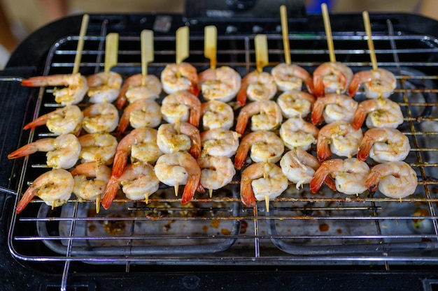 Gegrillte Buttergarnelen am Herd aufspießen