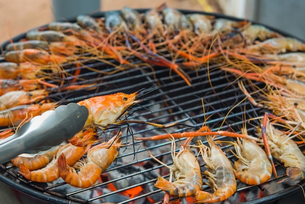 Gegrillte Garnelen auf einem Stahlrahmen mit heißem Feuer