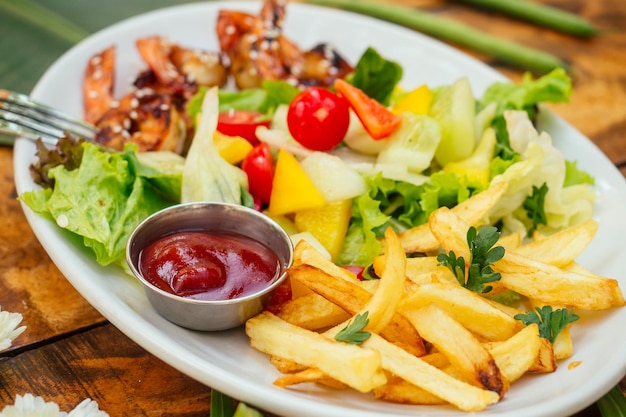 Gegrillte Garnelen und Bratkartoffeln auf dem Teller oben