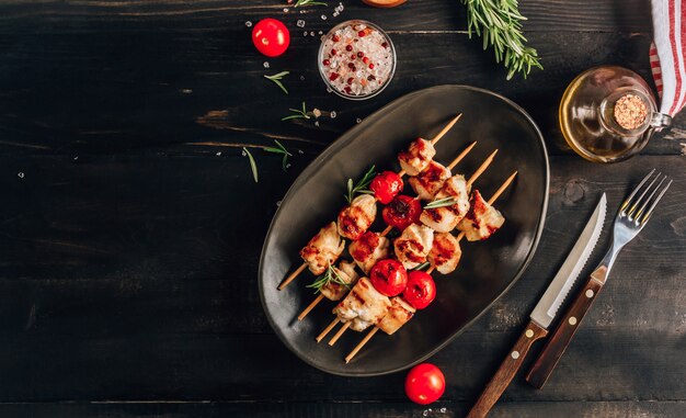 Gegrillte Hähnchen-Spieße mit Kirschtomaten auf einem Teller