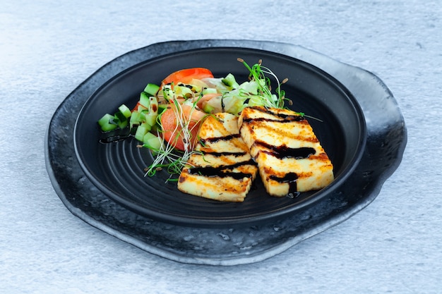 Gegrillte Halloumi-Käsescheiben mit Gemüsesalat, Tomaten und Gurken