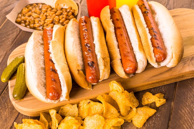 Gegrillte Hotdogs auf weißen Hotdog-Brötchen mit Pommes und Baked Beans an der Seite.