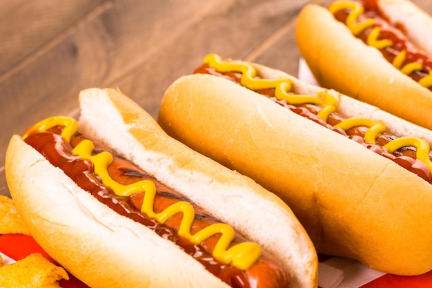 Gegrillte Hotdogs auf weißen Hotdog-Brötchen mit Senf und Ketchup.