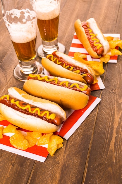 Gegrillte Hotdogs mit Senf und Ketchup auf dem Tisch mit Fassbier.