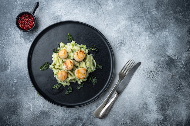 Foto gegrillte jakobsmuscheln mit kartoffelpüree, draufsicht, auf grauem tisch