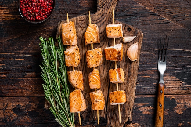 Gegrillte Lachs-Fisch-Kebab-Spieße auf Holzbrett