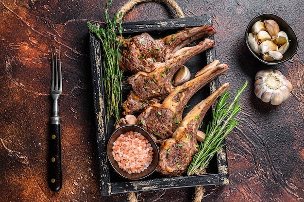 Gegrillte Lammkotelettsteaks in einem Holztablett.