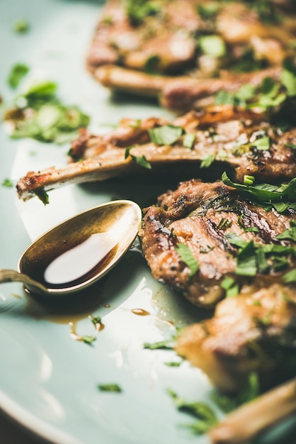 Gegrillte Lammrippen mit grüner Petersilie und Soßennahaufnahme