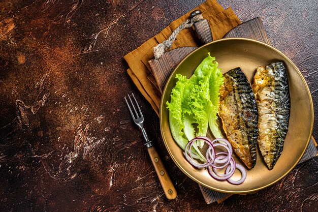 Gegrillte Makrelen-Scomber-Fischfilets mit Beilage in einem Teller Dunkler Hintergrund Draufsicht Kopierbereich