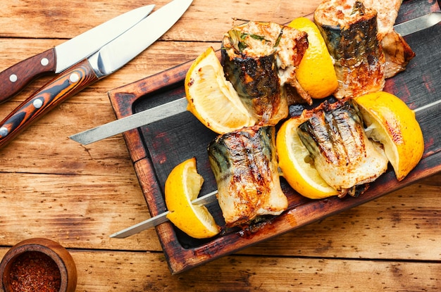 Gegrillte Makrelenspieße. Fischgrillspieß auf altem Holztisch