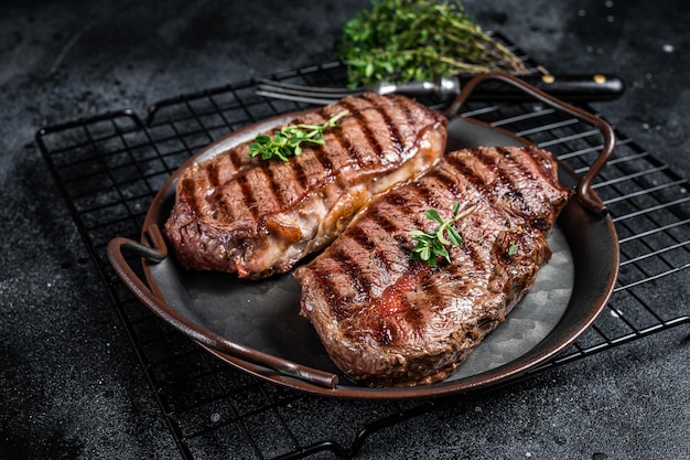 Gegrillte Oberklinge oder Flacheisen-Rindfleischsteaks Schwarzer Hintergrund Draufsicht