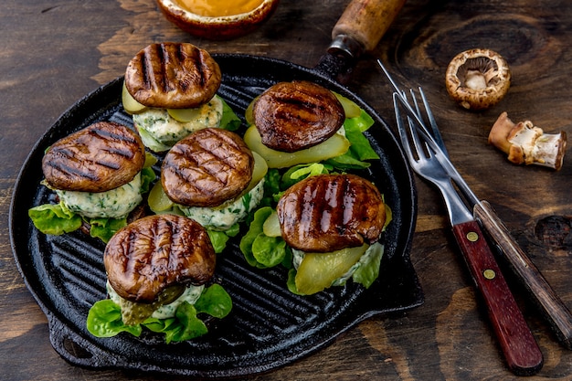 Gegrillte Portobello-Brötchen-Pilz-Burger auf Eisengrillpfanne