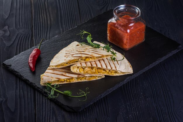 Gegrillte Quesadillas auf schwarzem Holzhintergrund