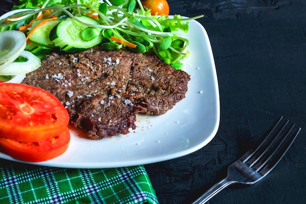 Gegrillte Rindersteaks und gesunde Salate auf dem Tisch