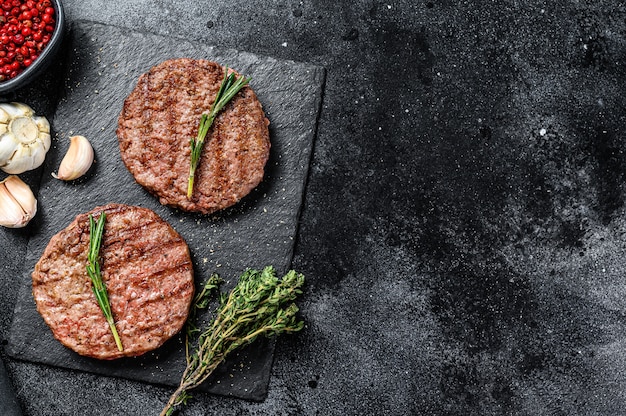 Gegrillte Rindfleisch-Burger-Pastetchen auf einem Steinbrett