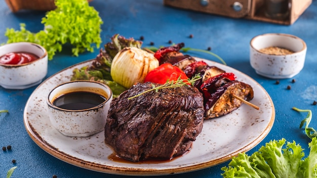 Gegrillte Rindfleischsteakgewürze und -gemüse auf einer Platte. Saftiges Fleischgemüse.