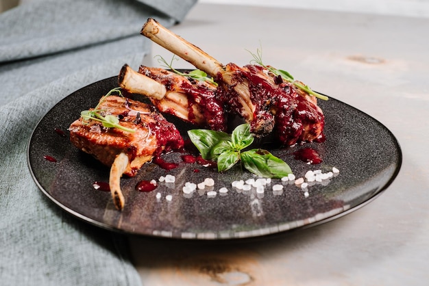 Gegrillte Rippchen mit roter Soße auf dem hölzernen Hintergrund