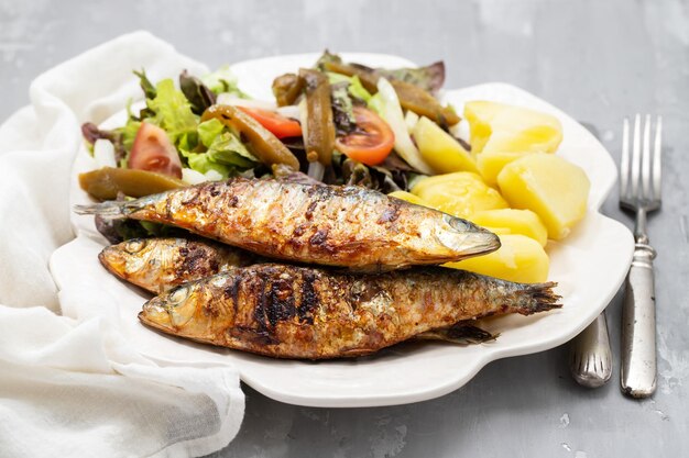 Foto gegrillte sardinen in einer metallschüssel im dunkeln