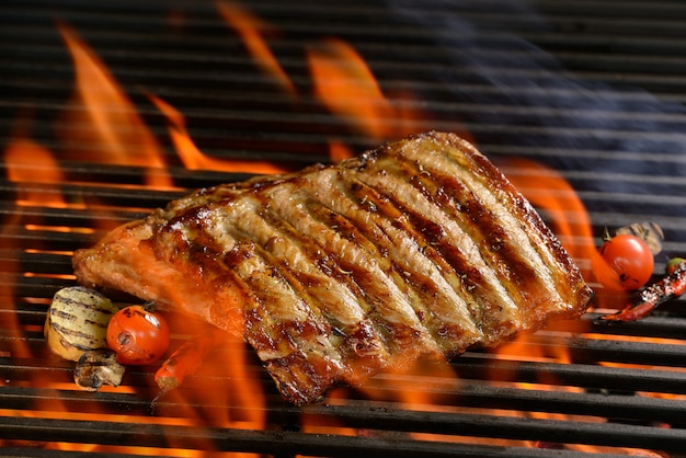 Gegrillte Schweinerippchen mit Gemüse auf dem lodernden Grill