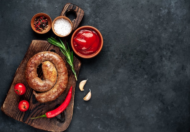 Gegrillte Spiralwurst mit Gewürzen auf einem Schneidebrett