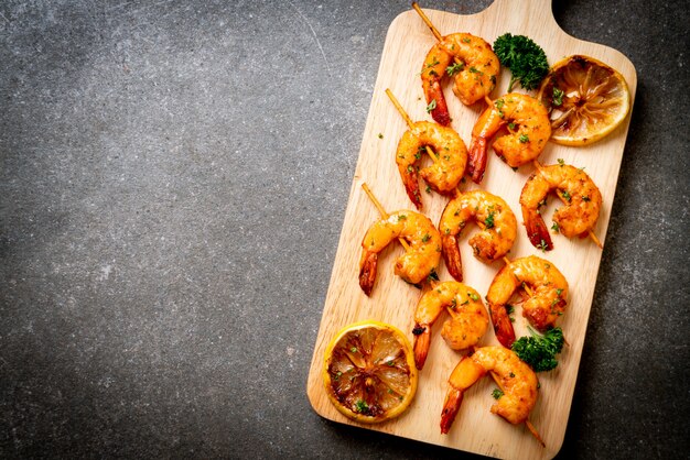 Foto gegrillte tiger shrimps spieße mit zitrone