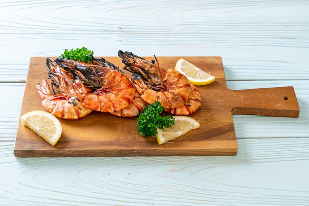 Gegrillte Tigergarnelen oder Garnelen mit Zitrone auf Holzbrett