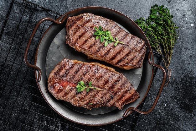 Gegrillte Top-Blade- oder Glätteisen-Rindfleischsteaks, schwarzer Hintergrund, Draufsicht
