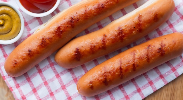 Foto gegrillte würstchen auf einer rosa tischdecke