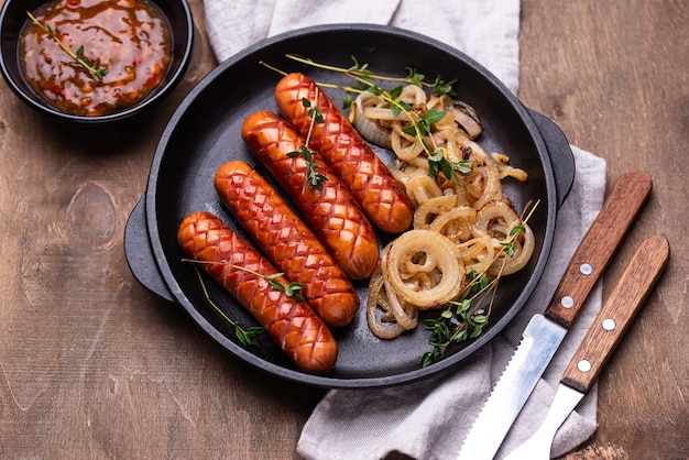 Gegrillte Würstchen mit gerösteten Zwiebeln und Chilisauce