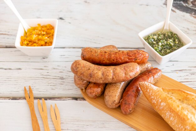 Gegrillte Würstchen mit Gewürzen und Saucen auf dem Tisch