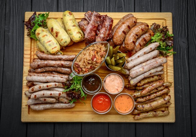 Gegrillte Würstchen mit Glas Bier auf einem Holztisch