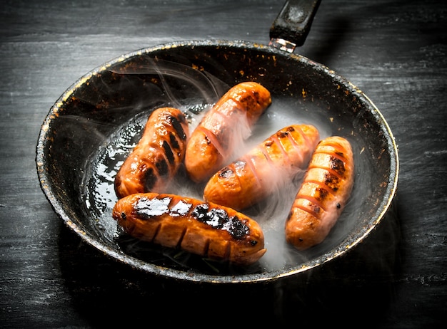 Gegrillte Wurst mit Rauch in der Pfanne