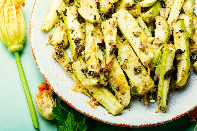 Gegrillte Zucchini mit Gewürzen und Kräutern. Gebratene Zucchini-Sticks auf dem Teller