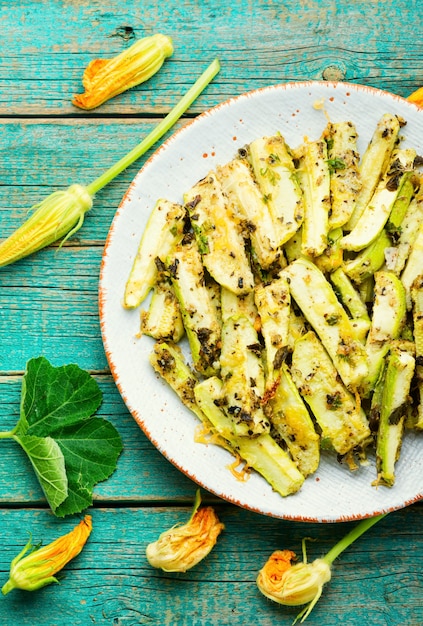 Gegrillte Zucchini mit Gewürzen und Kräutern. Gebratene Zucchini-Sticks auf dem Teller