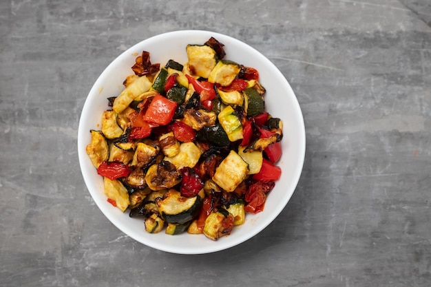 Gegrillte Zucchinipfeffer und Tomaten in einer kleinen weißen Schüssel