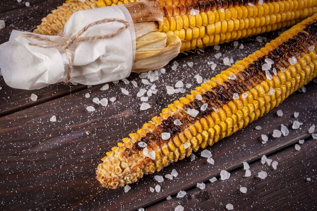 Gegrillter Bio-Mais mit Meersalz auf einem Holztisch