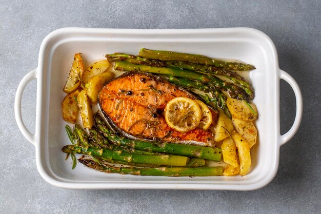 Gegrillter gebackener Lachs auf einem Teller mit Spargel und Kartoffeln