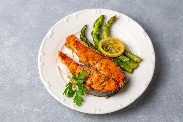 Gegrillter, gebackener Lachs, serviert auf einem Teller mit Spargel und Kartoffeln