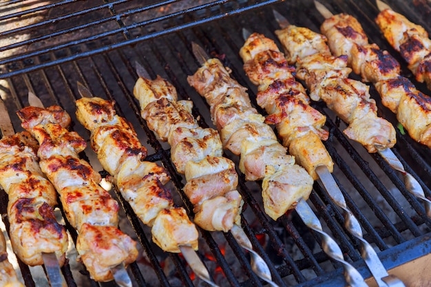 Gegrillter Kebab, der auf Metallaufsteckspindelnahaufnahme kocht. Gebratenes Fleisch am Grill gekocht.