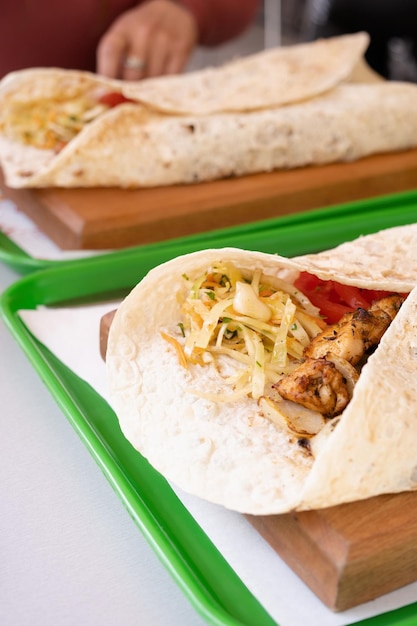 Gegrillter Kebab mit Fladenbrot und Gemüse auf einem Tablett im sommerlichen Fast-Food-Straßencafé