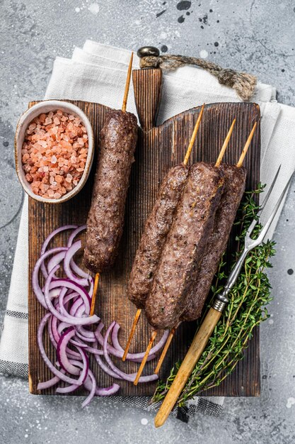 Gegrillter kofta kofte Schaschlik aus Hackfleisch vom Lamm und Rind auf Spieß grauer Hintergrund Ansicht von oben