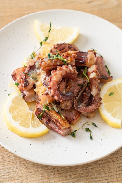 Foto gegrillter oktopus oder tintenfisch mit butter-zitronen-sauce und thymian